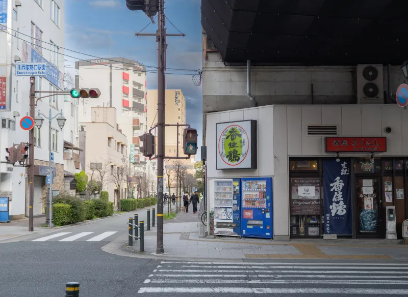 「川西能勢口駅11番出口」より外に出て、正面の横断歩道を渡り、左側の道を直進してください。